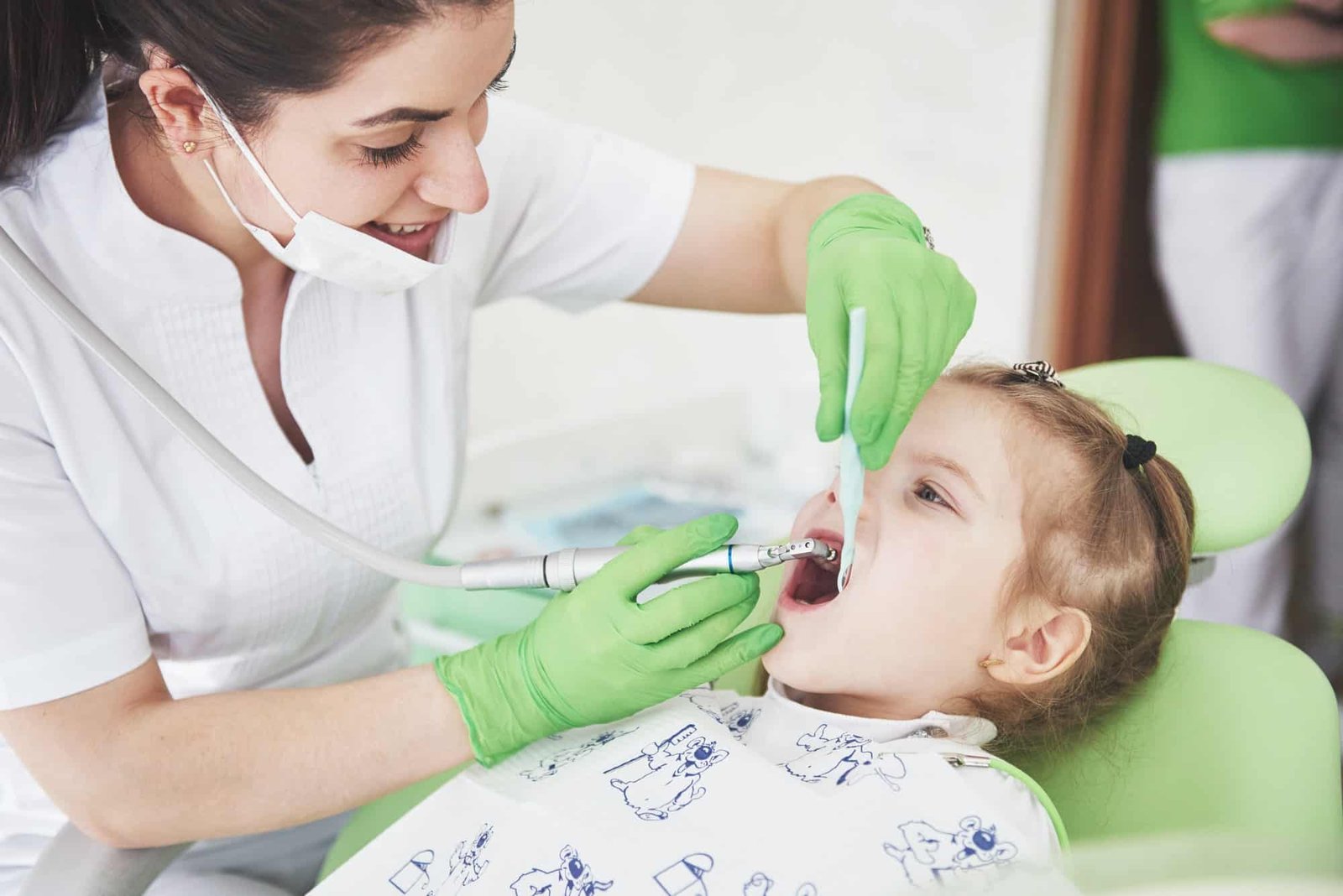 Teeth checkup at dentist's office. Dentist examining girls teeth in the dentists chair